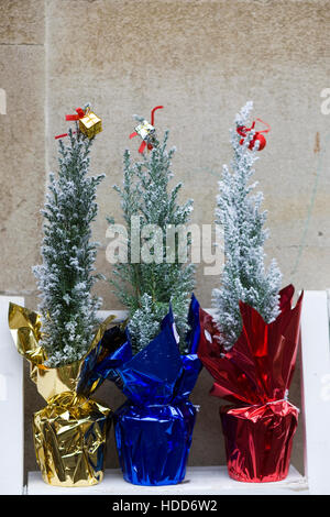 Miniature decorated Christmas trees in foil wrap Stock Photo