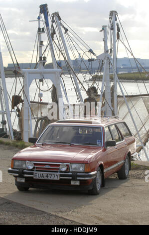 Ford Granada estate car on quayside with fishing boats behind Stock Photo