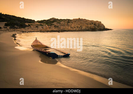 Old wooden boat wrecked on a sandy beach.