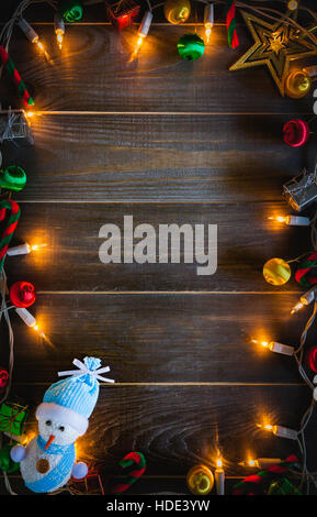 christmas background Snowman, gift boxes with lights and copy space on old wooden board background Stock Photo