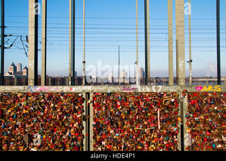 The bridge over the Rhine river in Cologne, Germany where the train passes by is full with locks Stock Photo