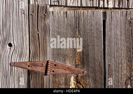 Rusted old hinge on a barn door Stock Photo