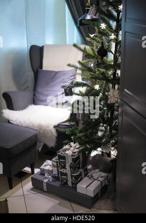 Christmas tree and a soft Chair in the room Stock Photo