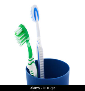 Pair of toothbrushes in blue plastic cup isolated over white background Stock Photo
