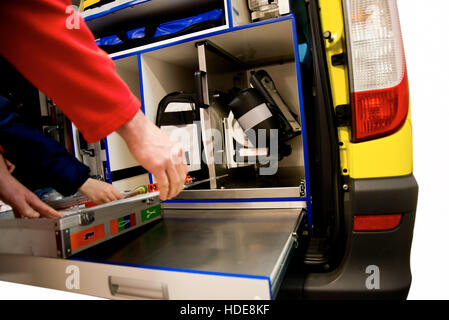 Paramedic gets his Expired Air Resuscitation from the back of emergency vehicle with open door and equipment inside. EMS Stock Photo