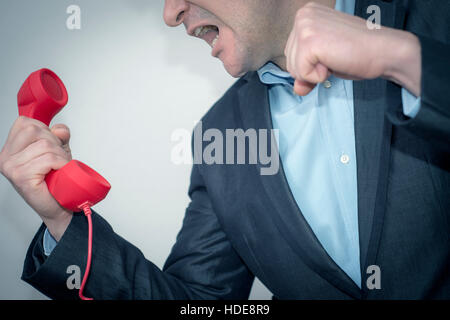 Young businessman with the phone,angry-violent. The Boss informs him that he did a good job Stock Photo