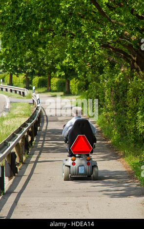 Old invalid man on a electrical vehicle Stock Photo