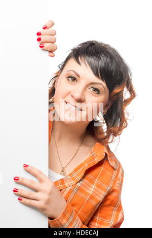 brunette girl looks out from behind a white poster Stock Photo