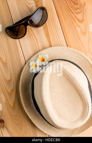 straw hat and sun glasses on the wooden floor view from above Stock Photo
