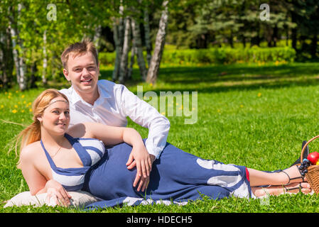 happy family pregnant couple in a summer park on a picnic Stock Photo