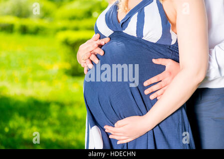 belly of a pregnant woman in the arms of the man she loved closeup Stock Photo