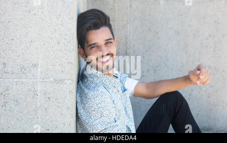 Handsome hipster with beard looking at camera outdoor in the summer Stock Photo
