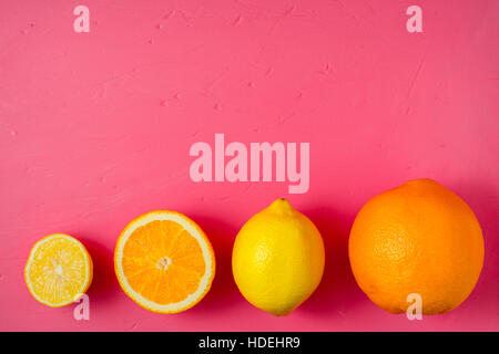 Lemons and oranges on the bright pink background Stock Photo