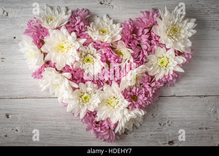 Heart made of flowers on the white scratched background top view Stock Photo