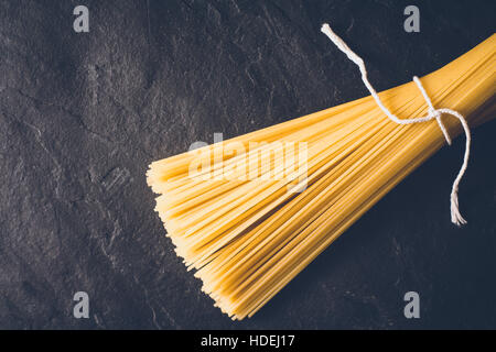 Raw spaghetti on the black stone background Stock Photo