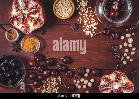 Different fruit and spices on the red wooden table. Concept of oriental fruits top view Stock Photo