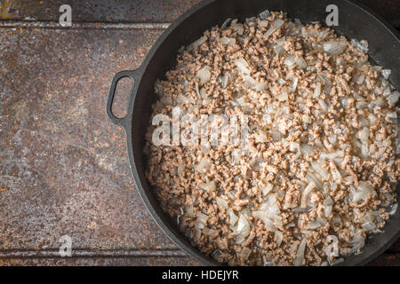 Fried minced meat with onion on the pan on the metal background top view Stock Photo