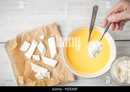 Adding cheese in the egg sauce top view Stock Photo