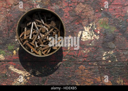 Nails in rusty tin can on a wooden background Stock Photo
