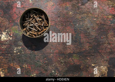 Nails in rusty tin can on a wooden background Stock Photo
