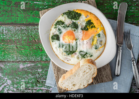 Florentine eggs with pureed spinach on the wooden table horizontal