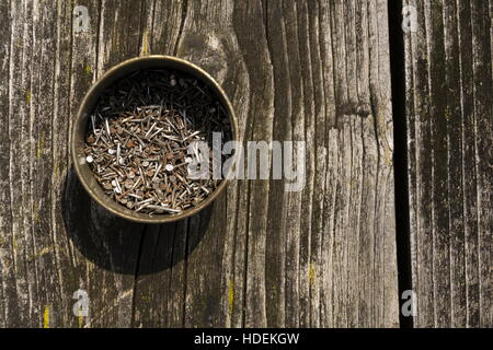 Nails in rusty tin can on a wooden background Stock Photo