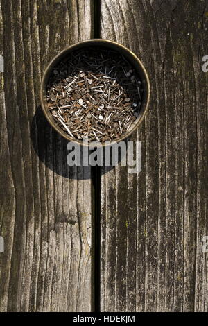 Nails in rusty tin can on a wooden background Stock Photo