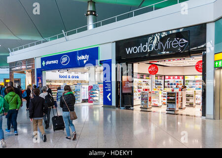 London, Heathrow airport, Terminal 2. Departure lounge interior. World Duty Free and Boots stores, both open. Some people. Not busy. Stock Photo