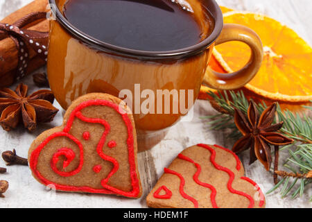 Fresh baked homemade decorated gingerbread and Christmas cookies, cup of coffee and spices on old white wooden background Stock Photo