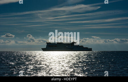 The Isle of Inishmore Irish ferry approaches Milford Haven on a glassy sea under blue skies with cirrus and cumulus clouds. Stock Photo