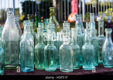 A row of Victorian glass bottles on a table at a car boot sale in London, England, UK Stock Photo
