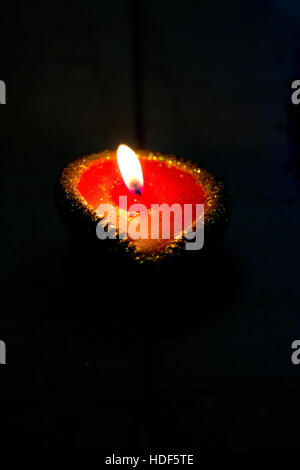 An oil lamp (diya) on a dark background during Diwali celebrations in India. Diwali is one of the biggest Indian festivals celebrated every year in In Stock Photo