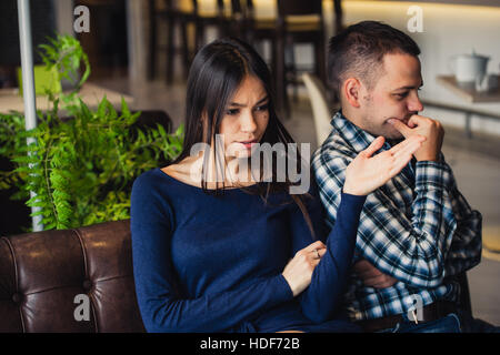 Couple at cafe during lunch. They are taking offense and sitting back Stock Photo
