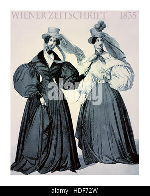 Vienna 1835 fashion, two young ladies elegant dressed with hat and scarfs for a walk with winding weather outdoors Stock Photo