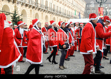 People dancing in a square with Santa Claus costumes in Italy. Stock Photo