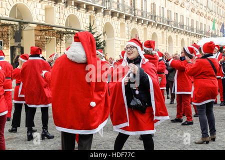 People dancing in a square with Santa Claus costumes in Italy. Stock Photo