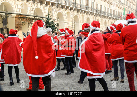 People dancing in a square with Santa Claus costumes in Italy. Stock Photo