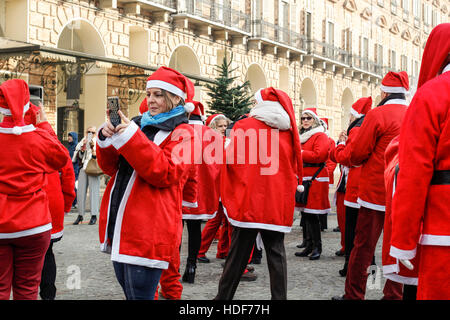 People dancing in a square with Santa Claus costumes in Italy. Stock Photo