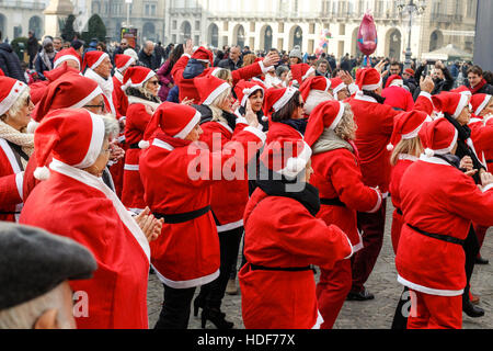 People dancing in a square with Santa Claus costumes in Italy. Stock Photo