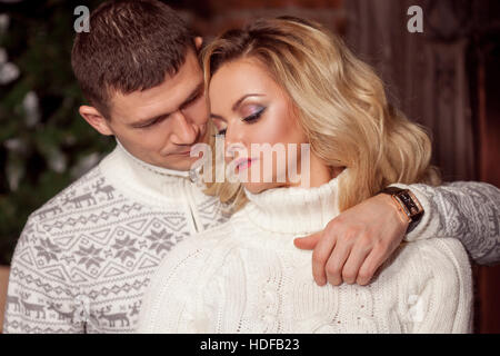 Man and a woman in warm knitted sweaters, hugging Stock Photo