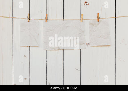 Blank old paper hanging on white wood background with space for text. Stock Photo