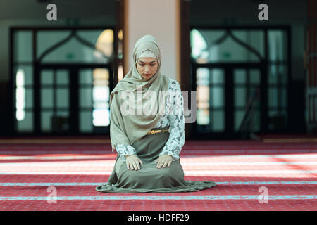 Young beautiful Muslim Woman Praying In Mosque Stock Photo