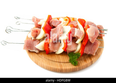 Kebab sticks with onion and pepper on a wooden plate isolated over white Stock Photo