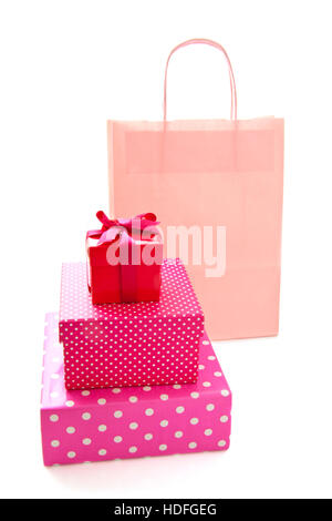 Pink bag with in front pink spotted gift boxes isolated over white Stock Photo