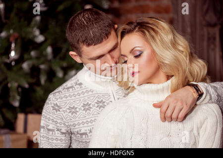 Man and a woman in warm knitted sweaters, hugging Stock Photo