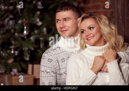 Man and a woman in warm knitted sweaters, hugging Stock Photo