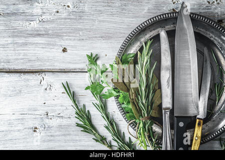 Metal plate with knifes and different  herbs on the white table Stock Photo