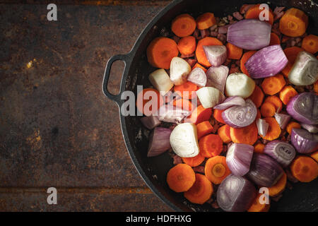 Shallot and carrots in the pan on the metal background Stock Photo