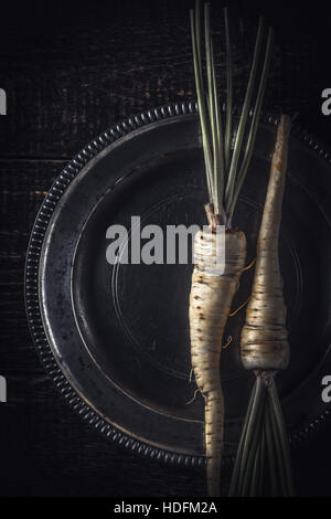 Parsley root  on the old metal plate  vertical Stock Photo