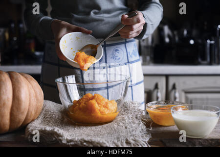 Putting pumpkin puree in the glass bowl horizontal Stock Photo